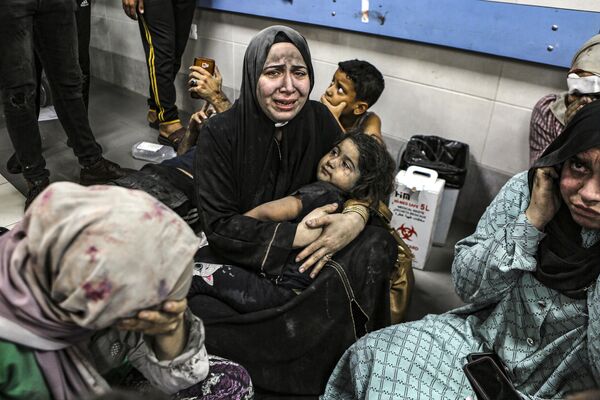 Wounded Palestinians sit in al-Shifa hospital in Gaza City, central Gaza Strip, after arriving from al-Ahli hospital following an explosion there, Tuesday, Oct. 17, 2023. The Hamas-run Health Ministry says an Israeli airstrike caused the explosion that killed hundreds at al-Ahli, but the Israeli military says it was a misfired Palestinian rocket.  - Sputnik Africa