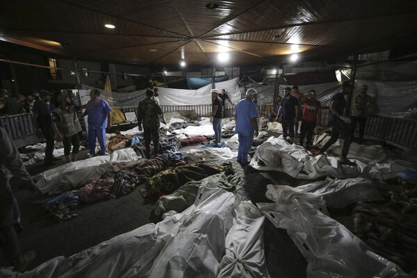 Bodies of Palestinians killed by an explosion at the Ahli Arab hospital are gathered in the front yard of the al-Shifa hospital, in Gaza City, central Gaza Strip, Tuesday, Oct. 17, 2023. The Hamas-run Health Ministry says an Israeli airstrike caused an explosion that killed hundreds at the Ahli Arab hospital, but the Israeli military says it was a misfired Palestinian rocket.  - Sputnik Africa