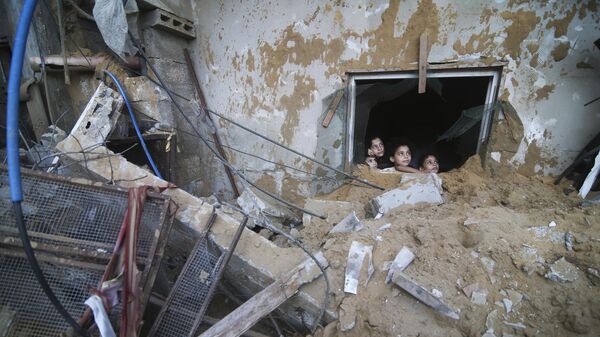 Palestinian children look at the building of the Zanon family, destroyed in Israeli airstrikes in Rafah, Gaza Strip - Sputnik Africa