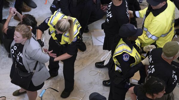 U.S. Capitol Police officers detain demonstrators protesting inside the Cannon House Office Building on Capitol Hill in Washington, Wednesday, Oct. 18, 2023.  - Sputnik Africa
