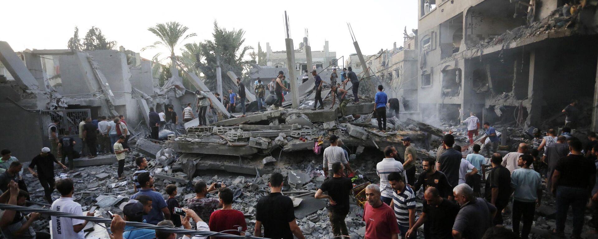 People search for victims and survivors following an Israeli strike on the town of Deir Al-Balah in the central Gaza Strip on October 18 2023.  - Sputnik Africa, 1920, 19.10.2023