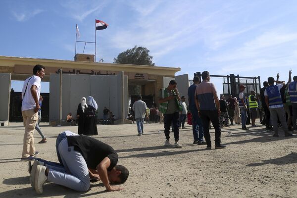Volunteers pray to thank God after trucks carrying humanitarian aid for the Gaza Strip crossed the Rafah border gate, in Rafah. - Sputnik Africa
