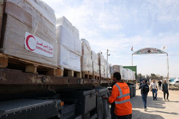 People gather around trucks carrying humanitarian aid that entered the Gaza Strip from Egypt via the Rafah border crossing on October 21, 2023.  - Sputnik Africa
