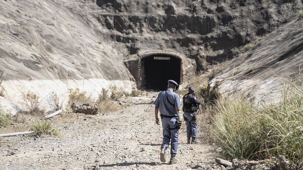 Members of the South African Police Service (SAPS) carry their weapons as they enter an abandoned mine during an operation in Stormhill west of Johannesburg on August 10, 2023 where territorial battles between illegal miners known as Zama Zamas has wreaked havoc in the area claiming the lives of several miners.  - Sputnik Africa