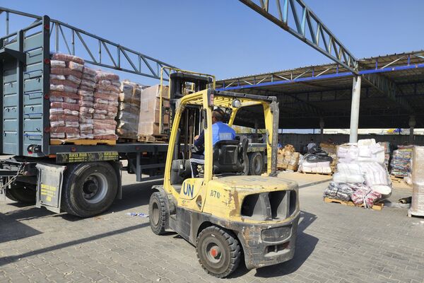 United Nations and Red Crescent workers prepare the aid for distribution to Palestinians at UNRWA warehouse in Deir Al-Balah, Gaza Strip, on Monday, Oct. 23, 2023. - Sputnik Africa