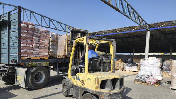 Сотрудники ООН и Красного Полумесяца готовят помощь для распределения среди палестинцев на складе в Дейр-эль-Балахе, сектор Газа - Sputnik Africa