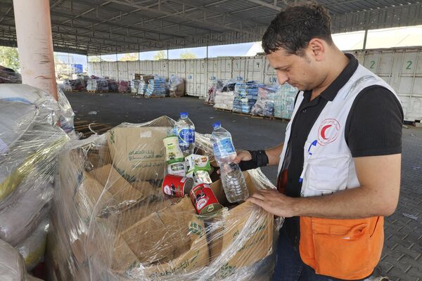 United Nations and Red Crescent workers prepare the aid for distribution to Palestinians at UNRWA warehouse in Deir Al-Balah, Gaza Strip, on Monday, Oct. 23, 2023.  - Sputnik Africa