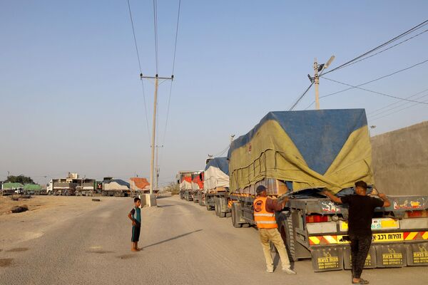 People unload humanitarian aid on a convoy of lorries entering the Gaza Strip from Egypt via the Rafah border crossing on October 21, 2023.  - Sputnik Africa