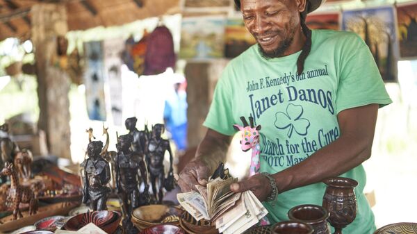 Thulani Ndlovu, shuffle through a wade of decommissioned Zimbabwe Bank notes at a crafts market in the Matobo national Park on February 17, 2023 in Matobo, Zimbabwe.  - Sputnik Africa