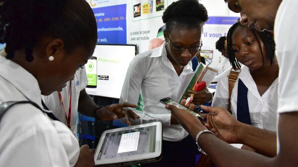 Visitors look at tablets and smartphones on the first day of the 2016 Africa Web Festival (AWF) in Abidjan on November 29, 2016.  - Sputnik Africa