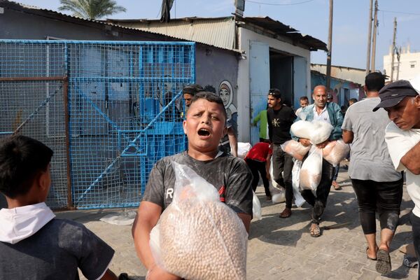 A Palestinian boy holds a bag of chickpeas collected from a UN-run aid supply center, distributing food to local Palestinians and people displaced following Israel&#x27;s call for more than 1 million residents in northern Gaza to move south for their safety, in Deir al-Balah on October 28, 2023, amid the ongoing battles between Israel and the Palestinian group Hamas. - Sputnik Africa