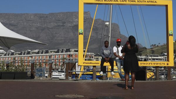 Visitors to Cape Town's popular V&A Waterfront are photographed against a backdrop of the city's Table Mountain, Friday, July 31, 2020. - Sputnik Africa