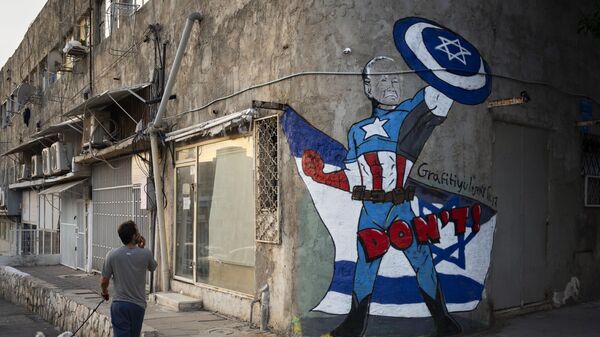 A man walks past a newly painted graffiti of Joe Biden depicts the U.S. president as a superhero defending Israel, Tel Aviv, Israel, Monday, Oct. 30, 2023. - Sputnik Africa