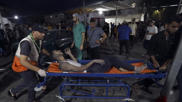 Un Palestinien blessé est transporté à l'hôpital al-Shifa suite aux frappes aériennes israéliennes sur la ville de Gaza,  le 26 octobre 2023 - Sputnik Afrique