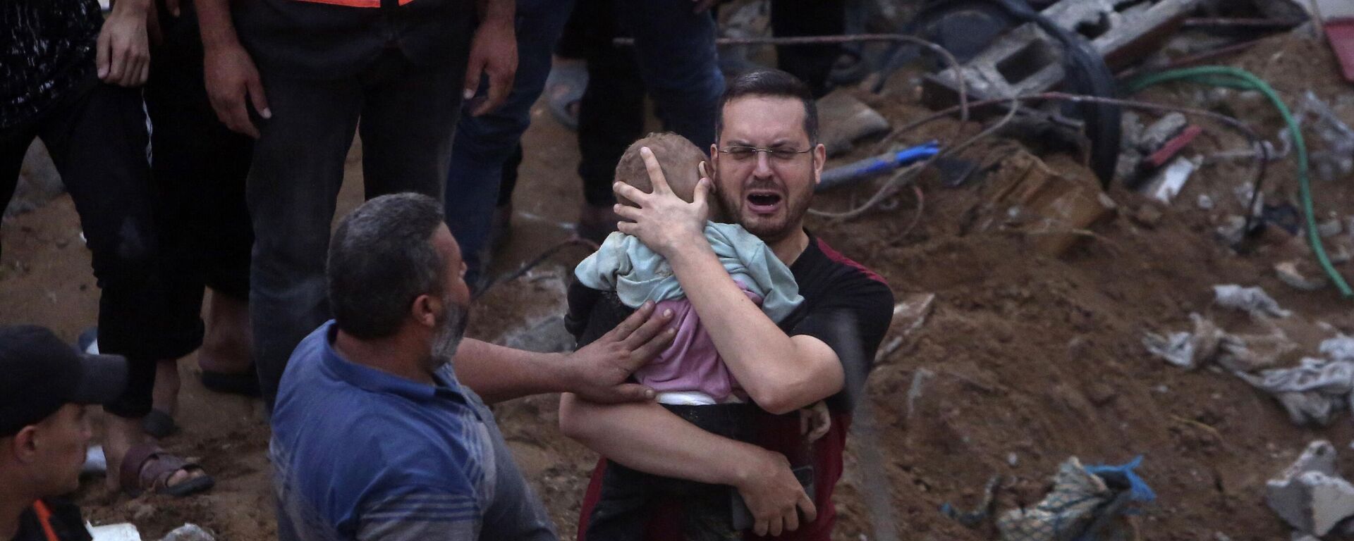 A greiving man holds a dead child after the Gaza Strip's Nusseirat refugee camp was hit by an airstrike. - Sputnik Africa, 1920, 01.11.2023