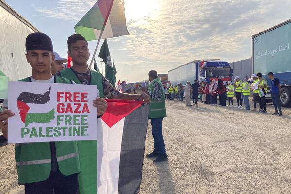 Volunteers boldly wave Palestinian flags and signs at the Rafah border crossing between Egypt and Gaza Strip, Tuesday, Oct. 31, 2023. - Sputnik Africa