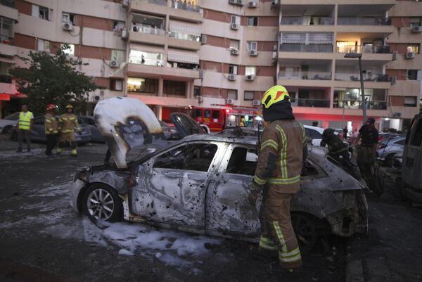 Israeli firefighters inspect the damage to vehicles and a residential building after it was hit by a rocket fired from the Gaza Strip, in Ashdod, southern Israel, Tuesday, Oct. 31, 2023. - Sputnik Africa