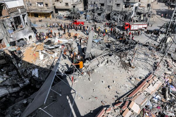 Crowds stand waiting as civil defense workers tirelessly search for victims and survivors in the rubble of a building struck by Israel&#x27;s bombardment in Rafah, located in the southern Gaza Strip, Oct. 31, 2023. - Sputnik Africa