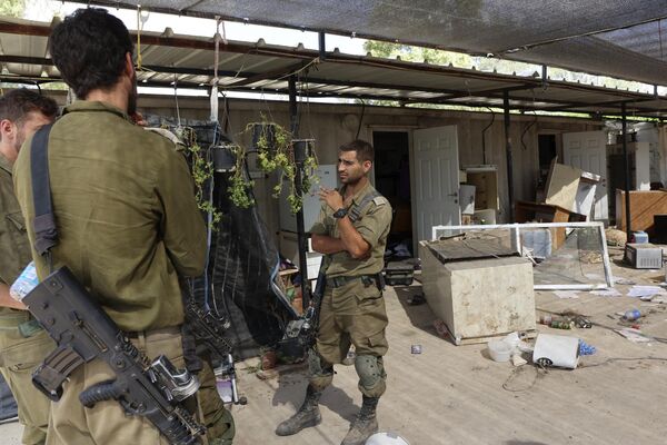 This picture from Oct. 31. 2023, taken during an Israeli military-led media tour, shows soldiers standing outside a ransacked house in the Nir Oz kibbutz, one of several Israeli communities near the Gaza Strip that fell victim to the infamous Oct. 7 ambush by the Hamas Palestinian militant group. - Sputnik Africa