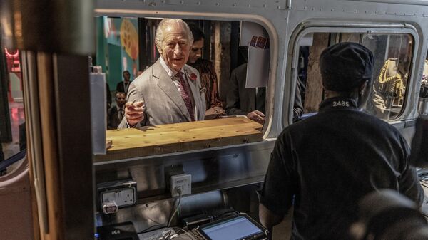 UK King Charles III (C) orders food from a food truck during a visit to Nairobi Street Kitchen in Nairobi - Sputnik Africa