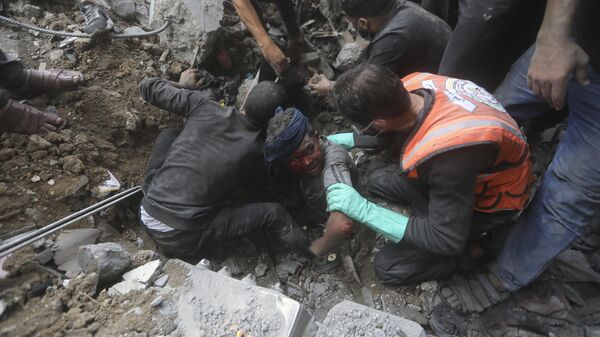 Palestinian rescuers try to pull an injured boy out of the rubble of a destroyed building following an Israeli airstrike in Bureij refugee camp, Gaza Strip, Thursday, Nov. 2, 2023. - Sputnik Africa