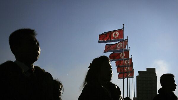 People stand near North Korean flags during a mass dance party as part of celebrations of the Day of the Shining Star or birthday anniversary of late North Korean leader Kim Jong Il on Tuesday, Feb. 16, 2016, in Pyongyang, North Korea.  - Sputnik Afrique