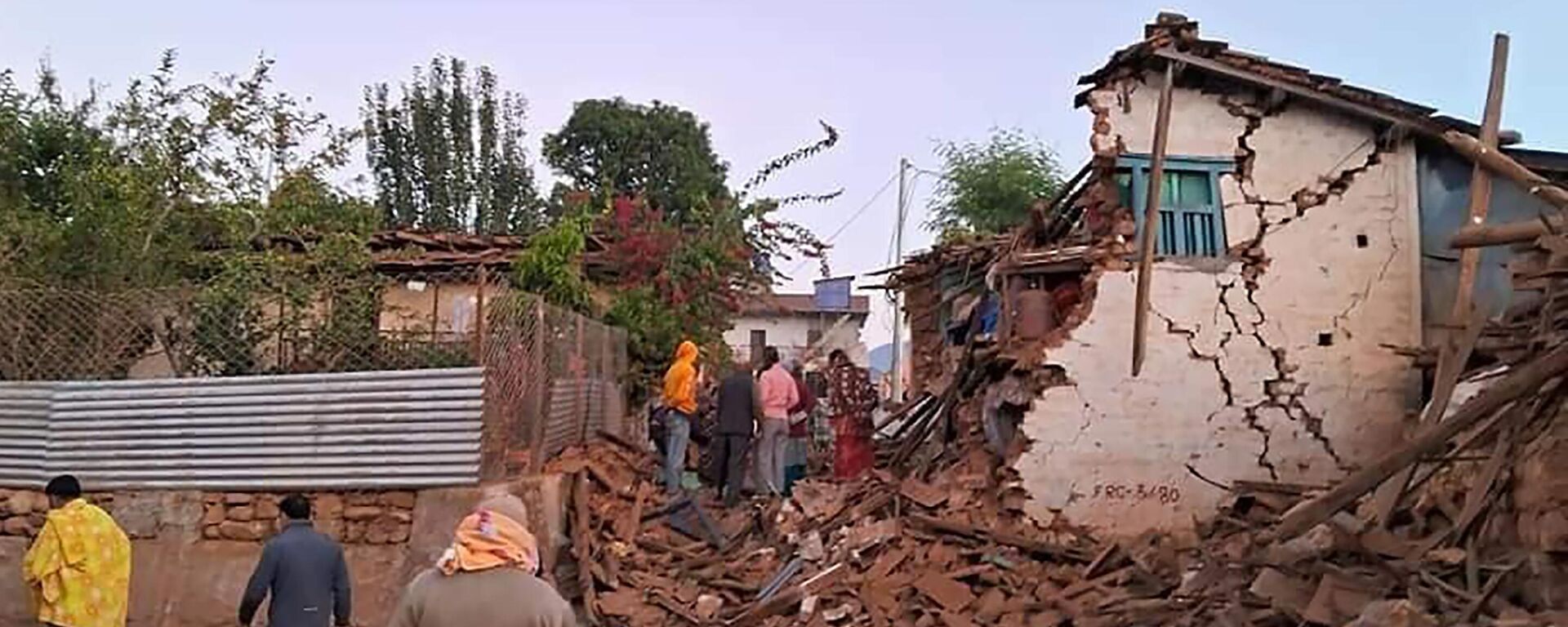 This screen grab from video shows villagers stand in front of their damaged houses from last night earthquake in Jagarkot, Nepal, Saturday, Nov. 4, 2023.  - Sputnik Africa, 1920, 04.11.2023