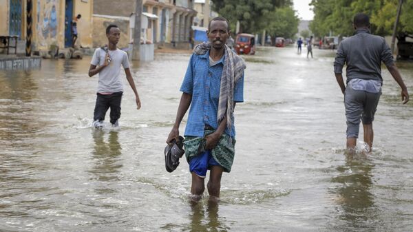 Men walk through floodwaters on a street in the town of Beledweyne, in Somalia, Monday, May 15, 2023. - Sputnik Africa