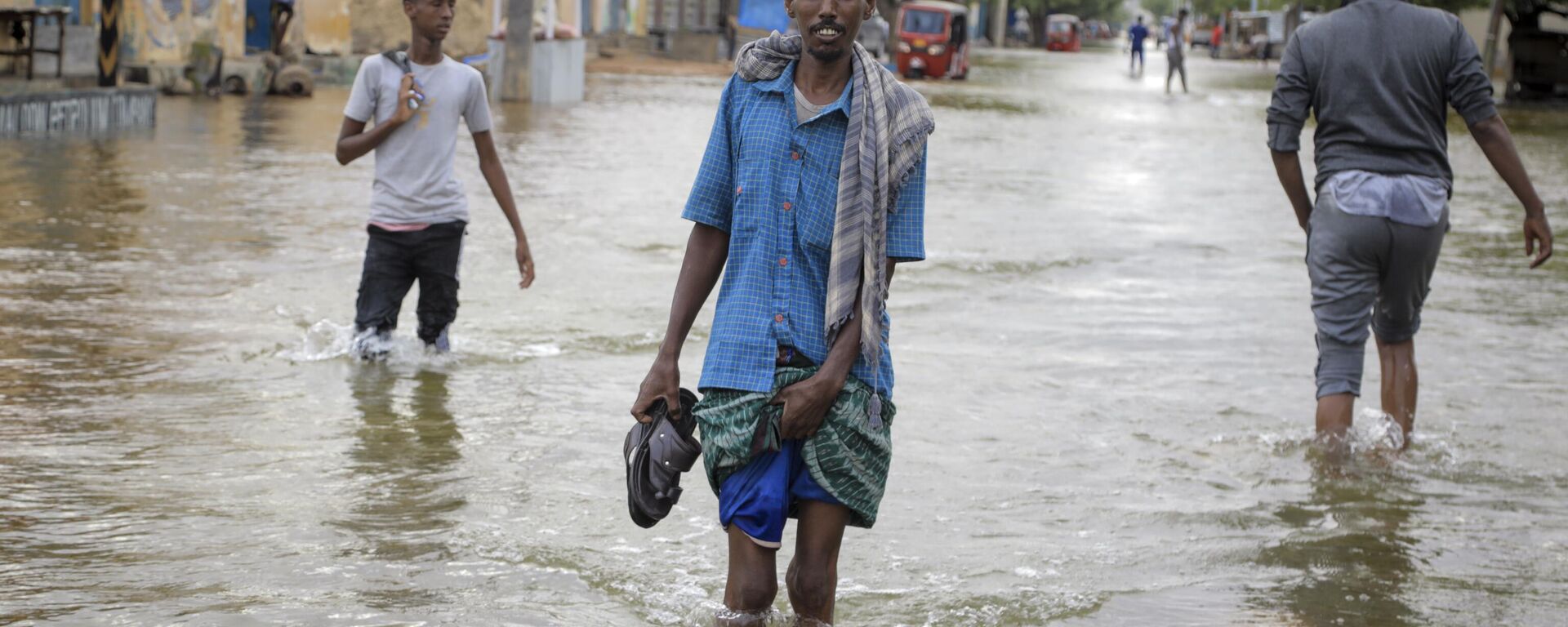 Men walk through floodwaters on a street in the town of Beledweyne, in Somalia, Monday, May 15, 2023. - Sputnik Africa, 1920, 12.11.2023