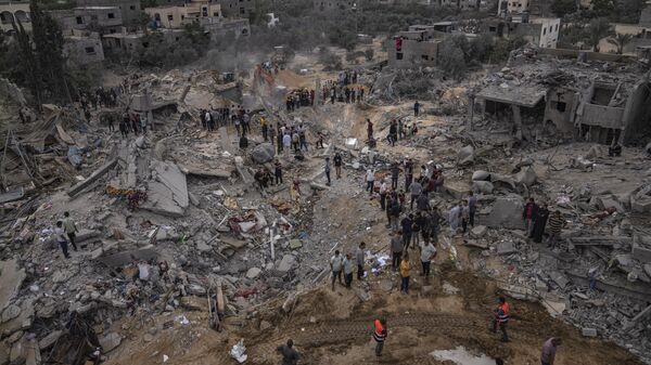 Palestinians look for survivors following an Israeli airstrike in Khan Younis, southern Gaza Strip, Sunday, Nov. 12, 2023. - Sputnik Afrique