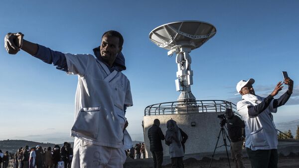 People take selfie pictures in front of a satellite antenna during the ceremony for the launching of the Ethiopian Remote Sensing Satellite (ETRSS) in Entoto Observatory and Research Centre in Addis Ababa, on December 20, 2019.  - Sputnik Africa