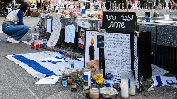 Une jeune femme près du mémorial pour la libération des citoyens israéliens retenus en otages par le Hamas sur la rue Dizengoff à Tel Aviv - Sputnik Afrique