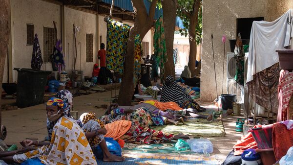 Dozens of women wait on mats outside the Ossaka Gazoby central maternity hospital in Niamey on May 8, 2020. - Sputnik Africa