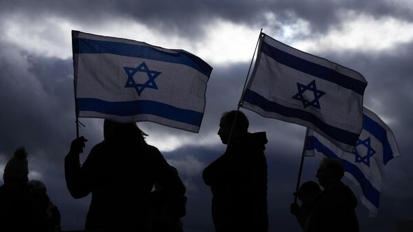 Demonstrators hold flags of Israel during a rally and march for Israel, Sunday, Nov. 19, 2023, in the Seattle suburb of Kirkland, Wash - Sputnik Africa