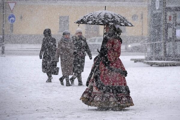A street performer wearing a 18 century costume walks in snowfall in St. Petersburg, Russia, Tuesday, Nov. 21, 2023.  - Sputnik Africa