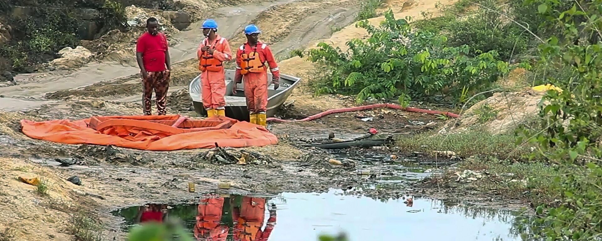 In this grab taken from video, workers stand by a container to collect oil spill waste, in Ogoniland, Nigeria, June 16, 2023 - Sputnik Africa, 1920, 24.11.2023