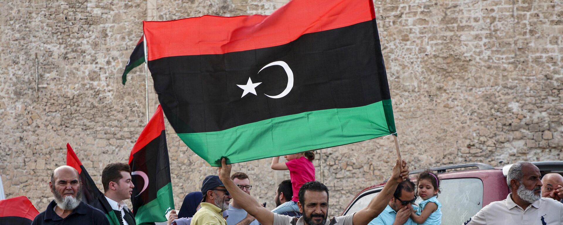 A man waves a Libyan national flag as people celebrate in the capital Tripoli on June 4, 2020, after the UN-recognised Government of National Accord (GNA) said it was back in full control of the capital and its suburbs. - Sputnik Africa, 1920, 24.11.2023
