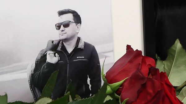 Flowers near the portrait of Rossiya 24 TV channel correspondent Boris Maksudov at the entrance to the VGTRK building. - Sputnik Africa