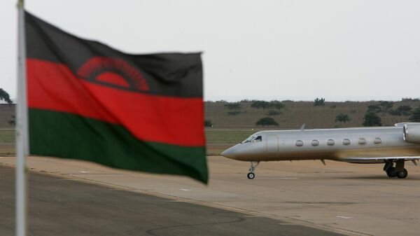 A private jet carrying U.S. singer Madonna taxis on the runway with a Malawian flag in the foreground at the Kamuzu international airport in Lilongwe, Malawi, Sunday, April 22, 2007.  - Sputnik Africa