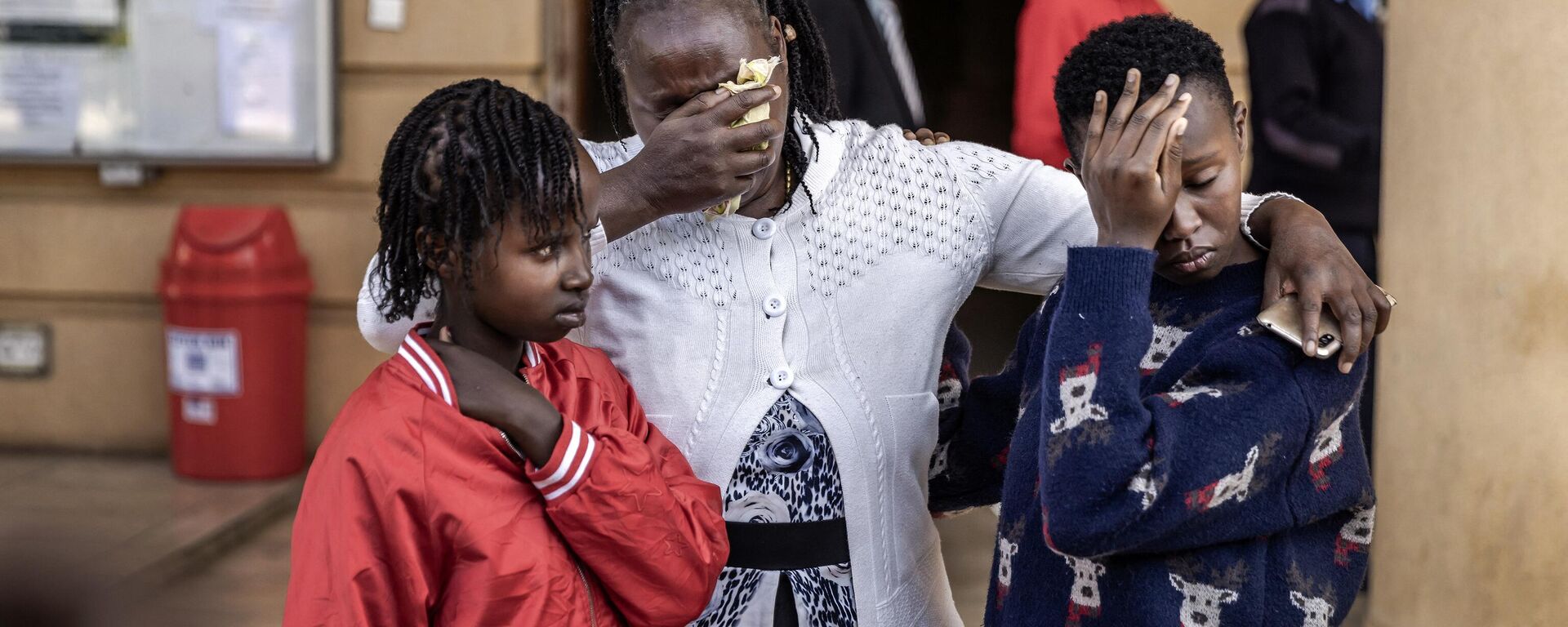 12-year-old Agnes Wanjiru's daughter Stacy Wanjiru (L), Agnes Wanjiru's sister Rose Wanyua (C) and Agnes Wanjiru's niece Esther Njoki (R) hug - Sputnik Africa, 1920, 30.11.2023