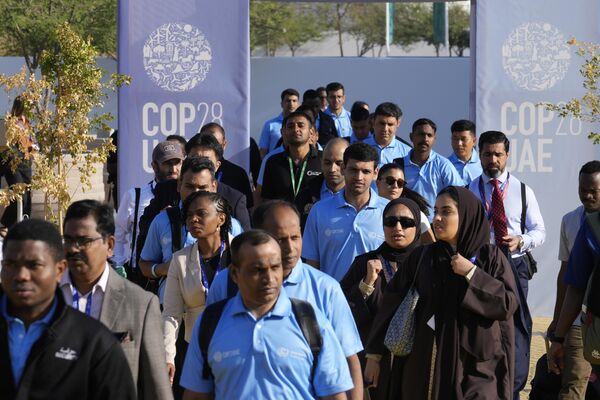 People walk through the venue at the COP28 U.N. Climate Summit, Friday, Dec. 1, 2023, in Dubai, United Arab Emirates. - Sputnik Africa