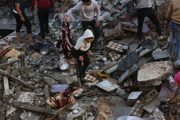 Palestinians inspect the destruction following an Israeli strike in Rafah in the southern Gaza Strip on December 1, 2023. - Sputnik Africa