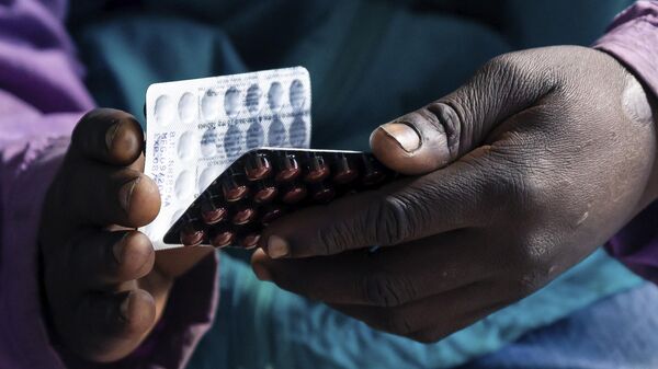 Blessing Chingwaru, 29, an HIV positive TB patient, holds a packet of tablets received as part of his treatment at Rutsanana Polyclinic in Glen Norah township, Harare June 24, 2019. - Sputnik Africa