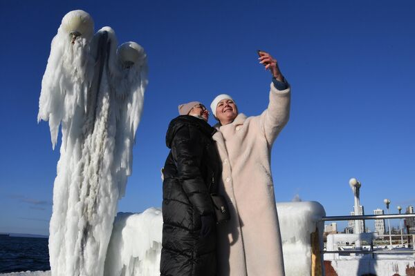 Women take photos on a frosty day on the icy Sportivnaya Gavan embankment in Vladivostok. - Sputnik Africa