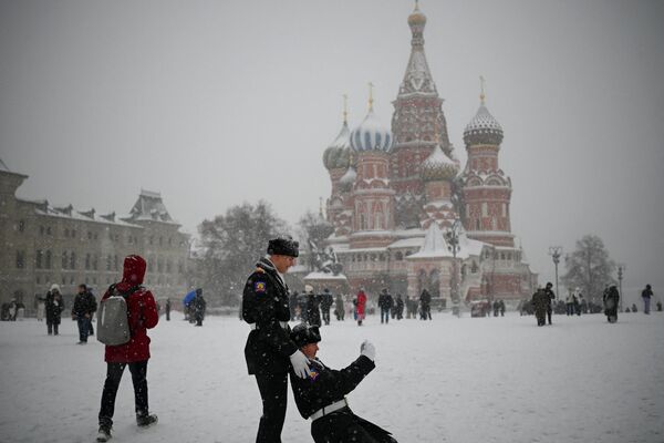 Russian cadets pose for a selfie in front of Saint Basil&#x27;s Cathedral in the snow-covered Red Square. - Sputnik Africa