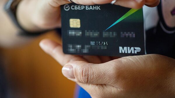A cardholder demonstrates her MIR credit card of SberBank in Yerevan, Armenia. Armenia has stopped using the Russian MIR payment system. - Sputnik Africa