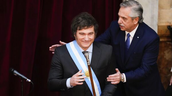 Argentina's outgoing President Alberto Fernandez pats incoming President Javier Milei after handing him the presidential sash at the Congress in Buenos Aires, Argentina, Sunday, Dec. 10, 2023.  - Sputnik Africa