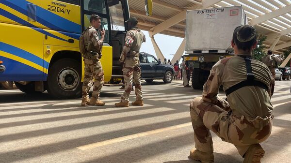 French soldiers assist mostly French nationals in a bus waiting to be airlifted back to France on a French military aircraft, at the international Airport in Niamey, Niger, Tuesday, Aug. 1, 2023.  - Sputnik Africa
