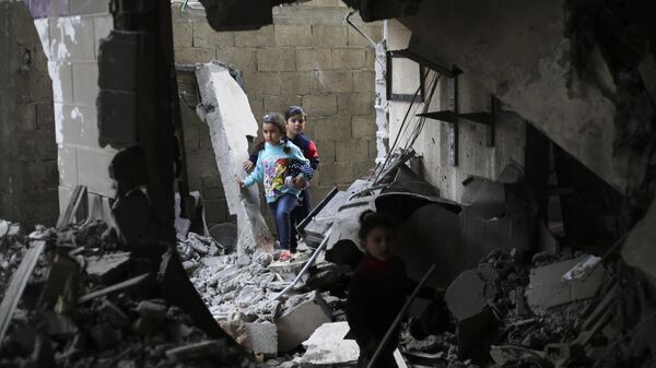 Palestinian children walk after an Israeli strike on residential buildings in Rafah, Gaza Strip - Sputnik Afrique