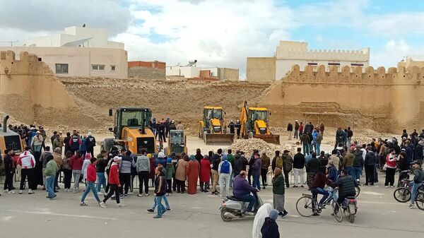 People and Civil Protection members gather at the site of a collapsed section of the ancient wall surrounding historic Kairouan in central Tunisia, killing three workers, on December 16, 2023. - Sputnik Africa